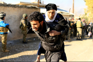 Man carrying woman from Moseul (Thaier Al-Sudani:Reuters)) Jan 5 2016